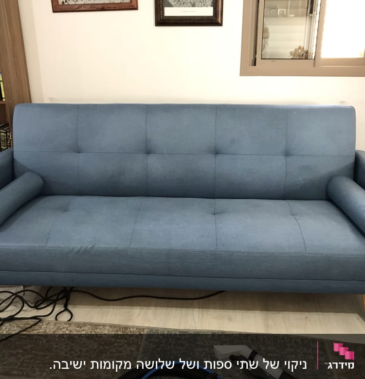 ספה כחולה עם מכשיר ניקוי על הרצפה